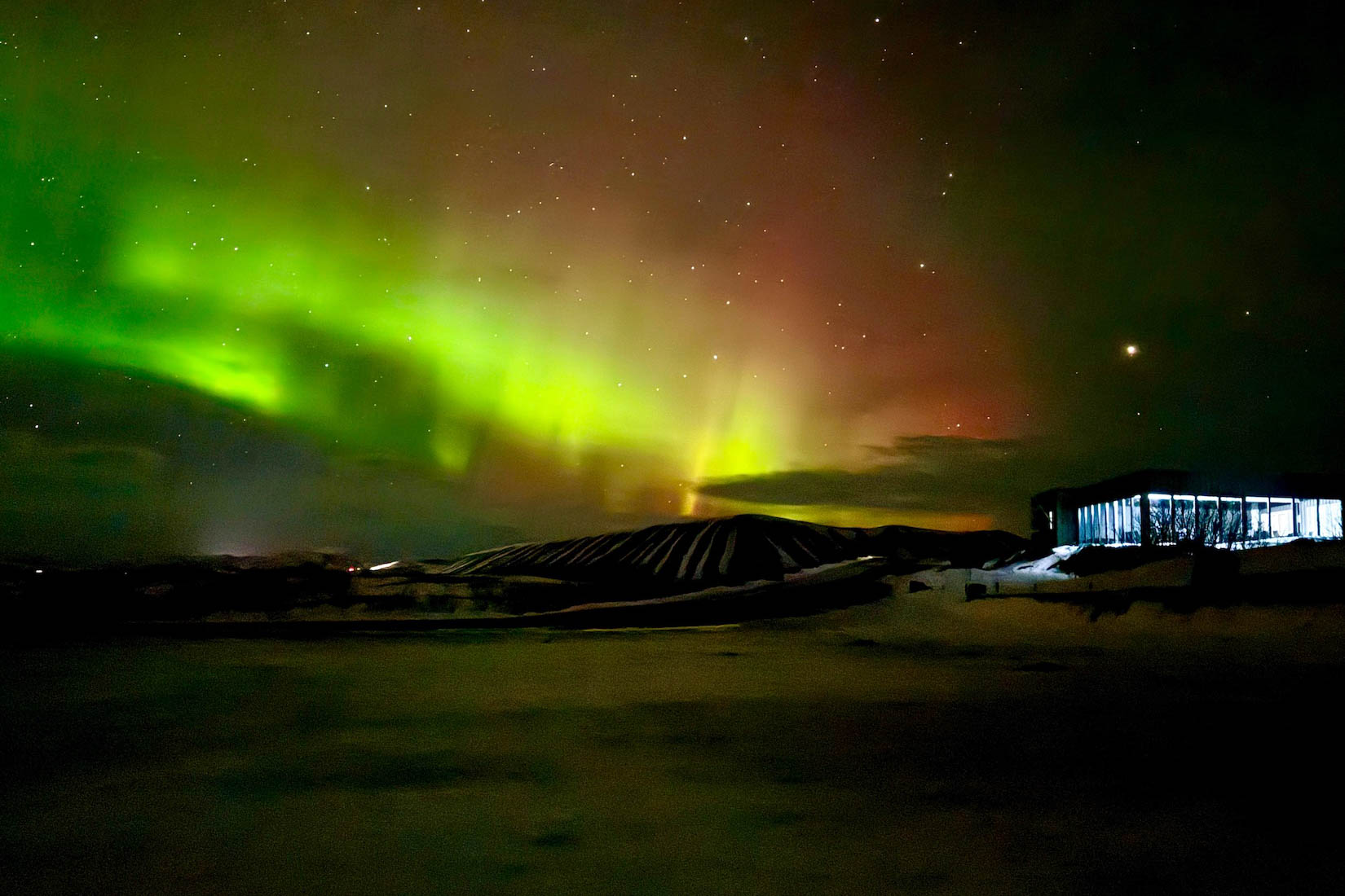 Hotel in IJsland met op de achtergrond het noorderlicht