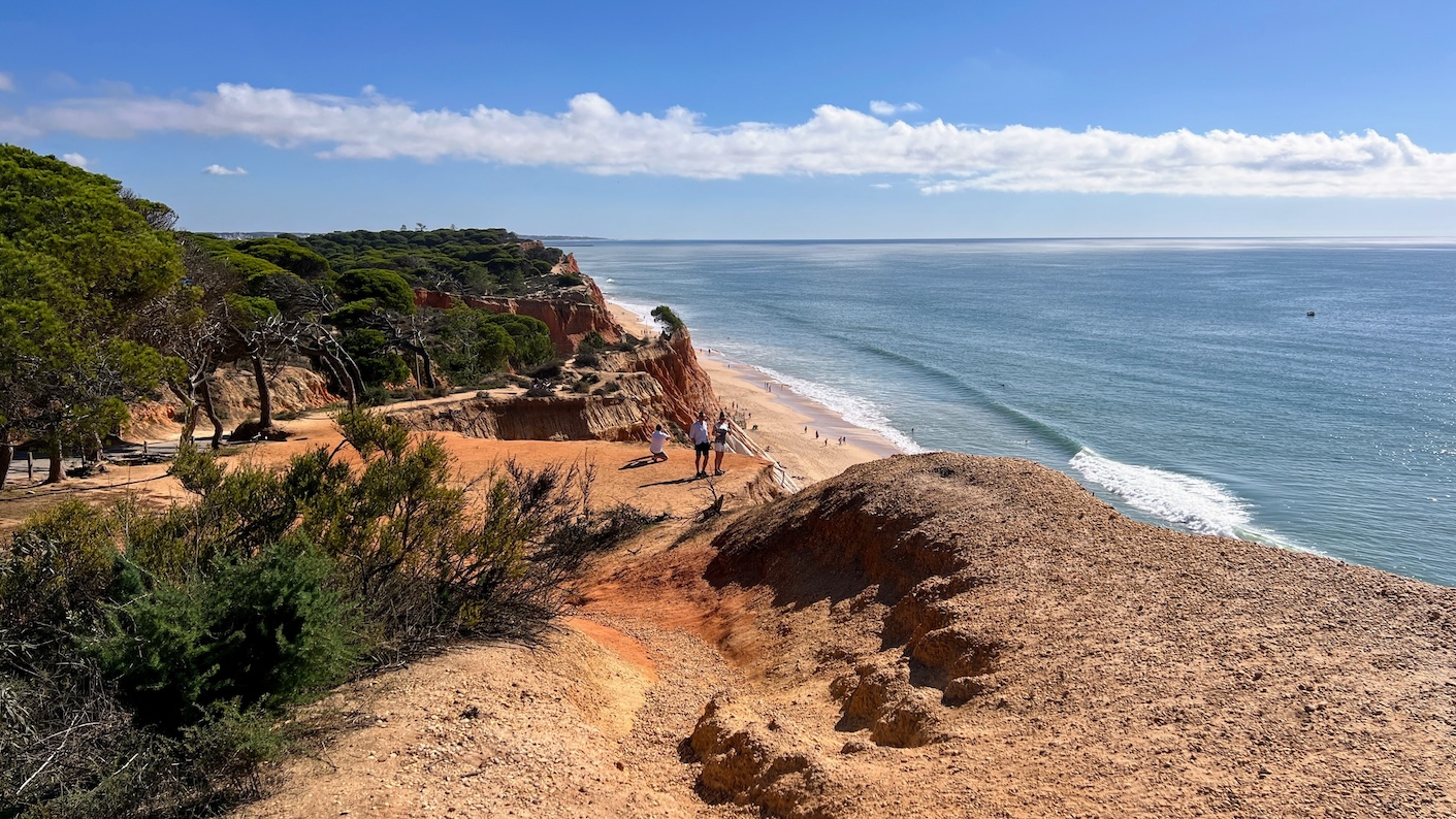 Hoge rode kliffen en een blauwe zee: het perfecte plaatje