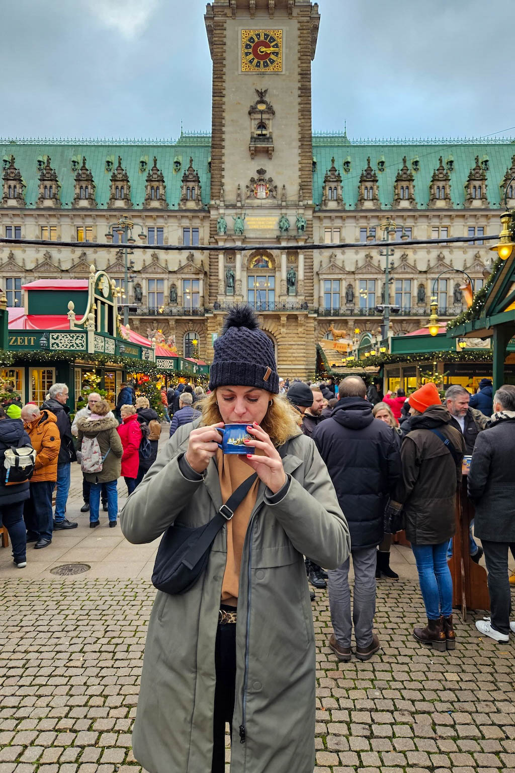 Vrouw drinkt glühwein op de kerstmarkt in Hamburg