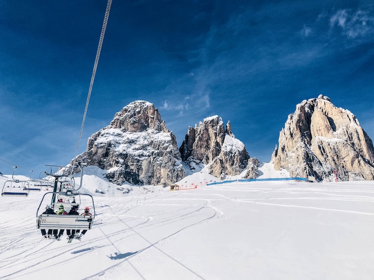 Skilift in de winter, met besneeuwde dolomieten op de achtergrond