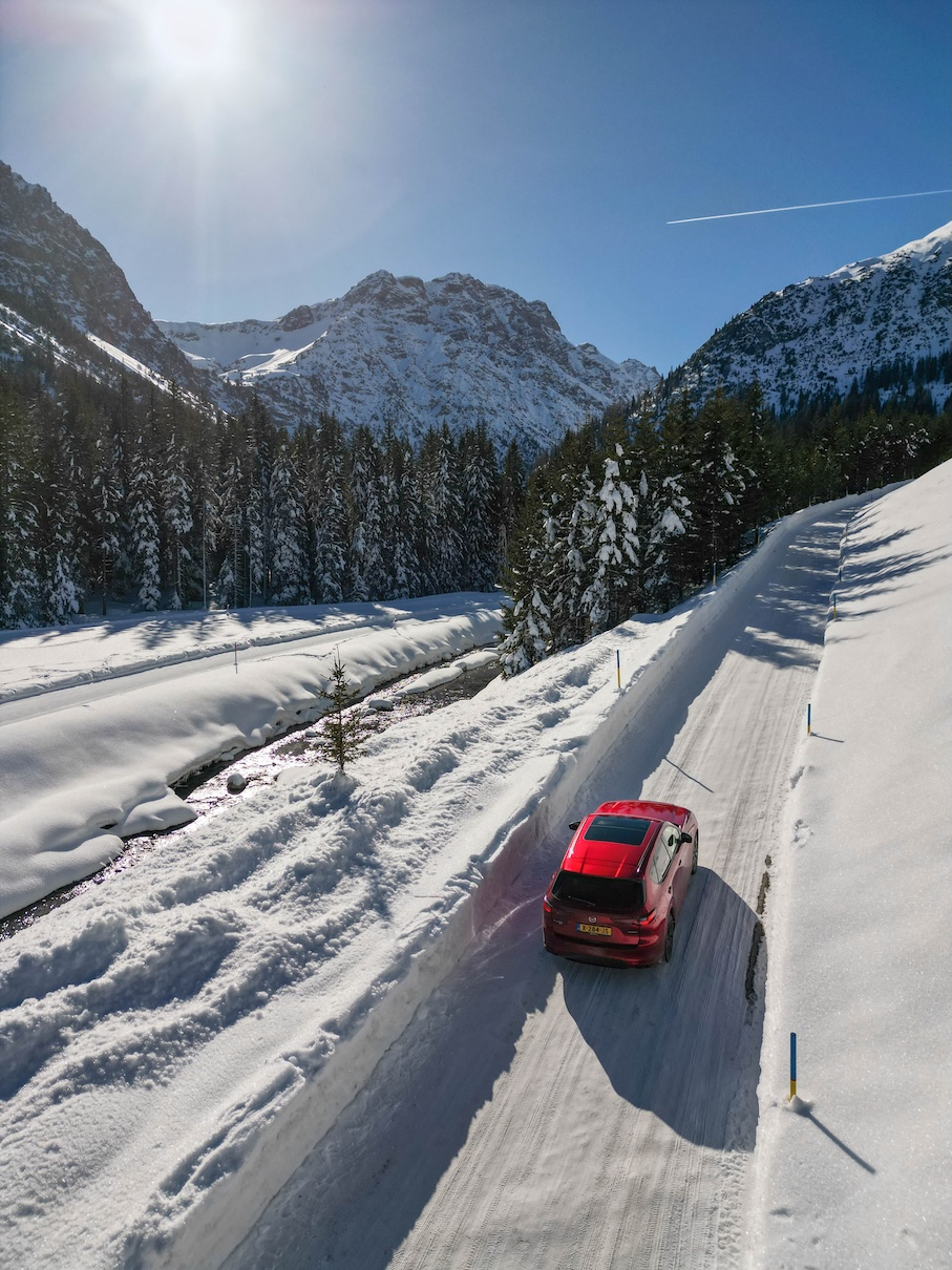 Rode Mazda op de Arosastrasse in de winter