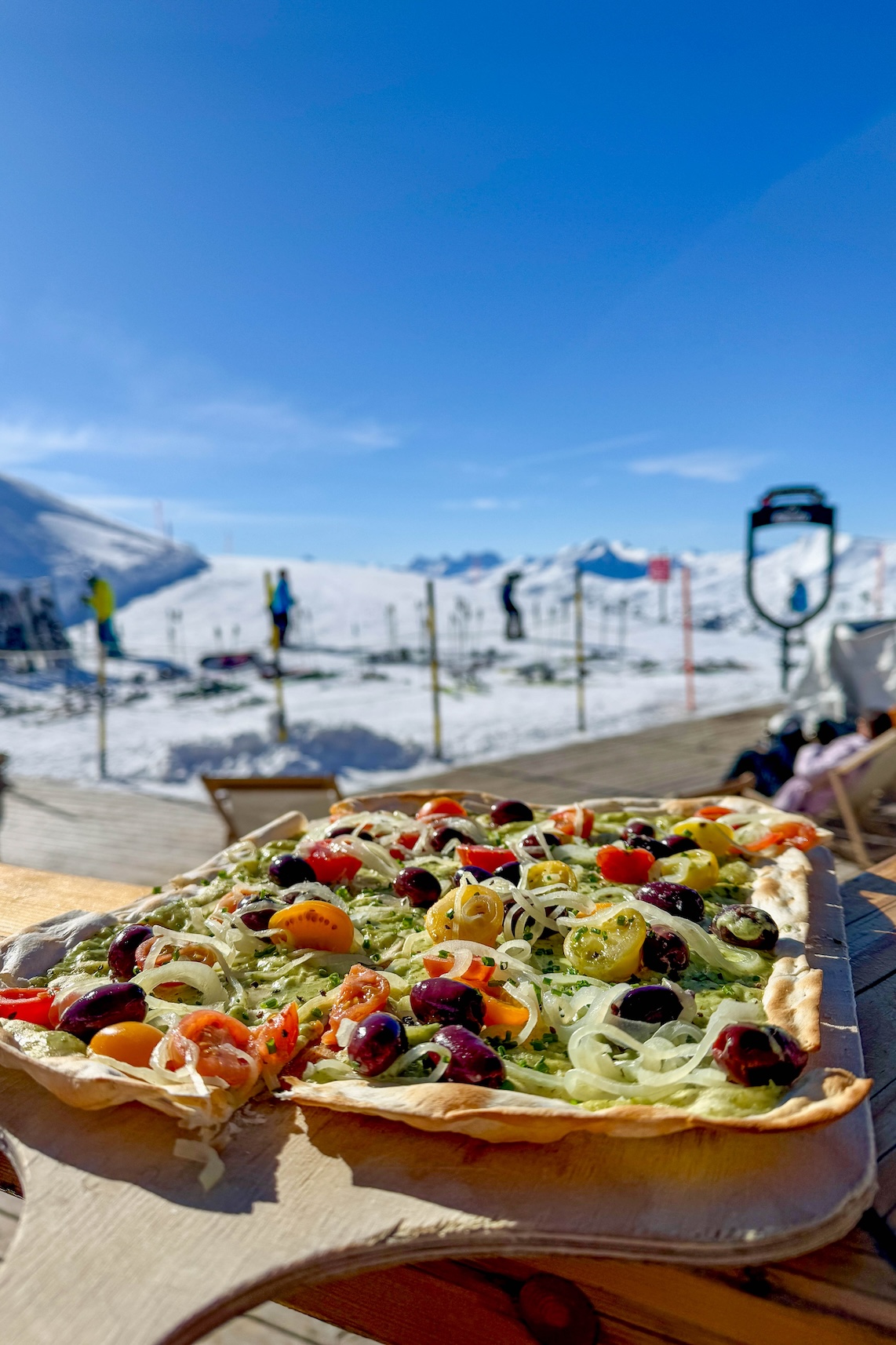 Lunch met flammkuchen op het terras in een berghut in Lenzerheide in de winter