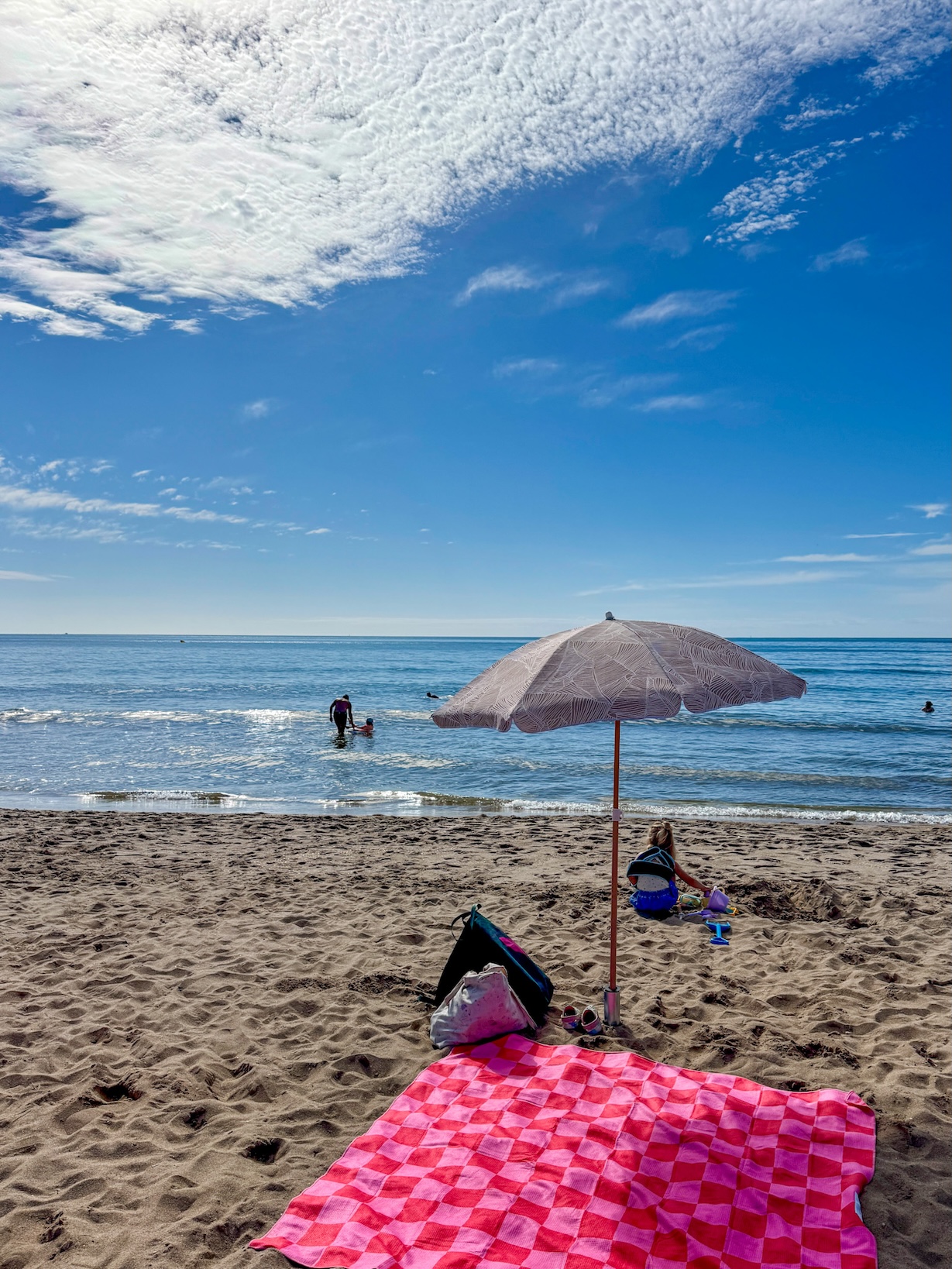 Parasol en strandlaken op het strand van Serignan