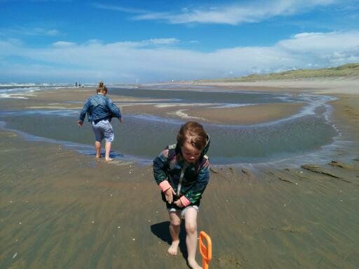 Op het strand is het scheppen en met water kliederen.