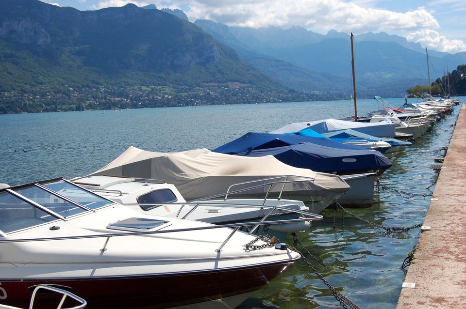 Aan de rand van het meer van Annecy liggen bootjes klaar om het water op te gaan