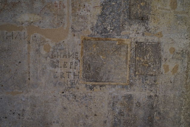In de muren gekerfde teksten uit een tijd toen de gebouwen nog dienst deden als gevangenis