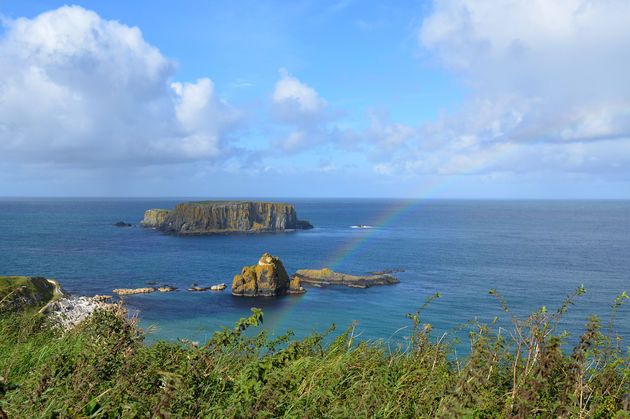 Een regenboog aan de kust bij Carrick-a-Rede