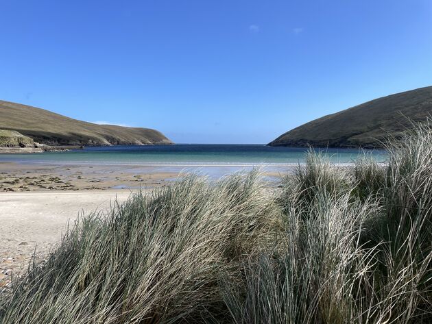 Bij Carrowteige beach heb je parelwitte zandstranden en een helderblauwe zee. Je zou bijna een tropische vibe krijgen, het zeewater is hier toch een heel stuk koeler. Mooi is het wel! Hier start de Carrowteige beach loop hike.