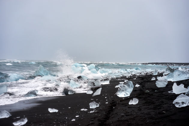 Vlakbij Jo\u0308kulsa\u0301rlo\u0301n ligt er een zwart strand met spiegelachtige ijsrotsen