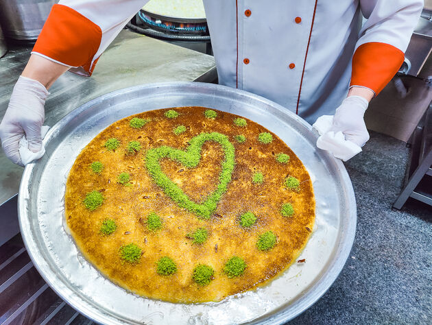 Het eindresultaat: k\u00fcnefe met gekruimelde pistachenoten als dessert