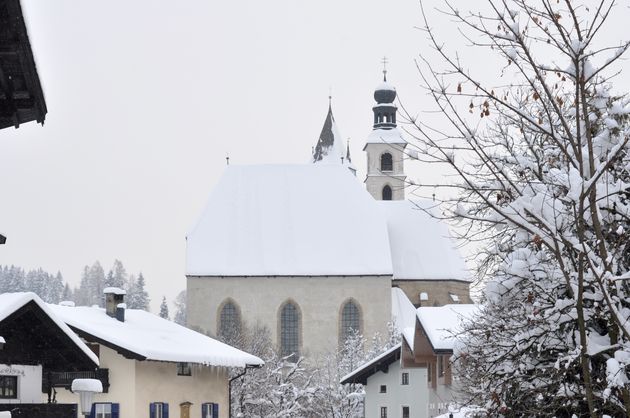 De kerk van Kitzb\u00fchel onder een dikke laag verse sneeuw