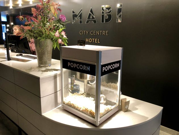De balie van Mabi City Centre Hotel, waar je nat\u00fa\u00farlijk popcorn kunt scheppen