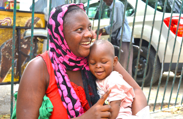 Een moeder met haar kindje op de markt in Dakar