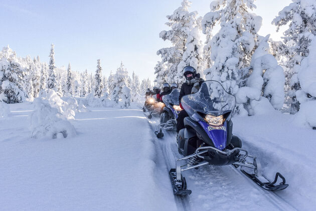 Op een sneeuwscooter scheuren door een sprookjesachtig wit landschap