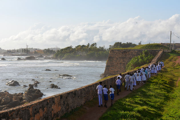 Lokale kids wandelen over de vestingmuur van Galle