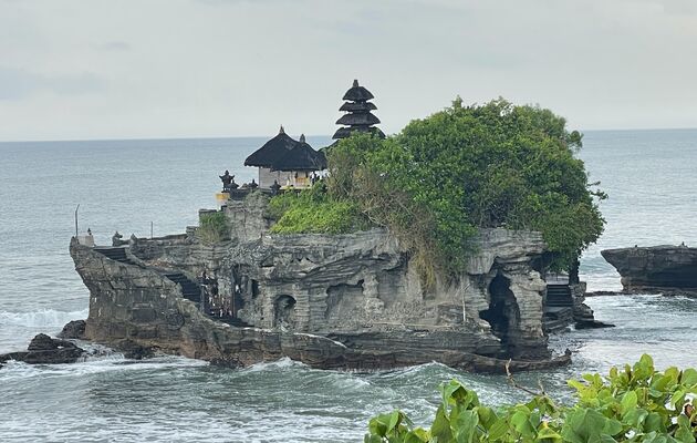 <em>De mystieke Pura Tanah Lot ligt op een rots in zee.<\/em>
