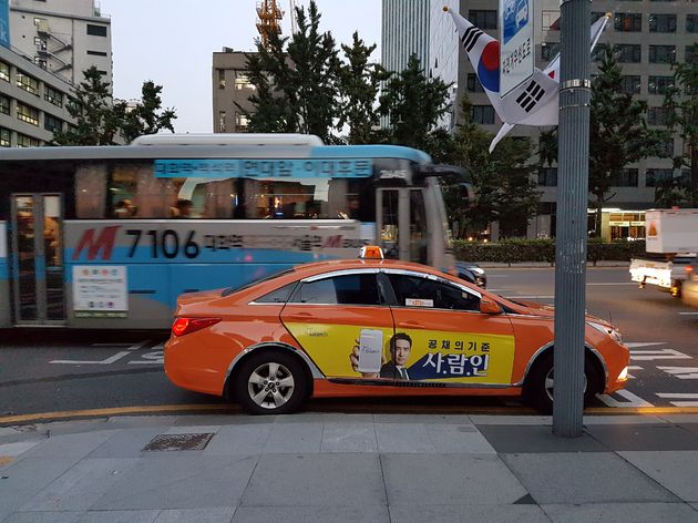 Oranje `cabs` en blauwe bussen in Seoul