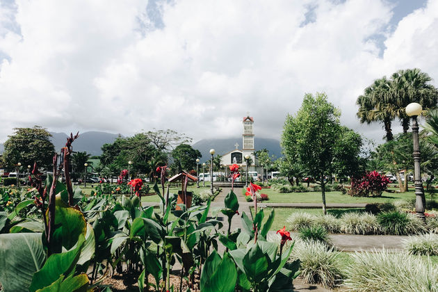 Verstopt achter de wolken en het kerkje: vulkaan Arenal