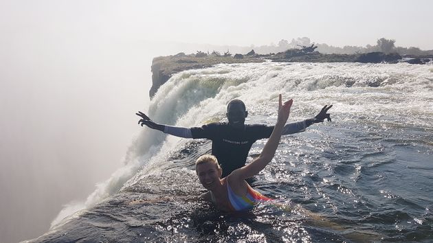 Lig op de rand van de Victoria Falls vanuit Devil`s Pool